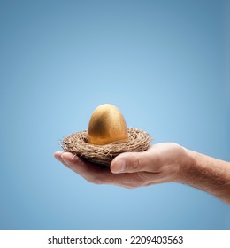 Retirement Savings Pension Golden Nest Egg In A Mans Hand Background With Copy Space