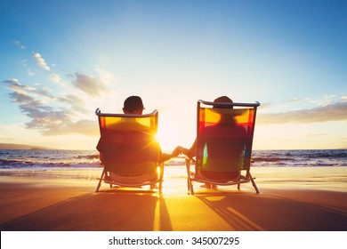 Konzept für den Ruhestand, glückliches reife, müde Paar, das den schönen Sonnenuntergang am Strand genießt