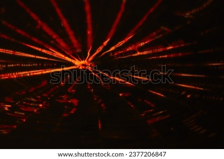 Retouched image in which thin red-yellow light streaks spread out like ripples, like fireworks reflected on the water surface.