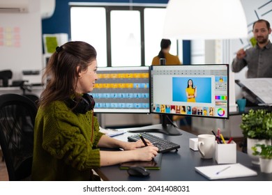 Retoucher woman editor working on computer with two monitors and stylus pencil in photo editing software sitting in creative agency office. Graphic designer retouching client photos using image app