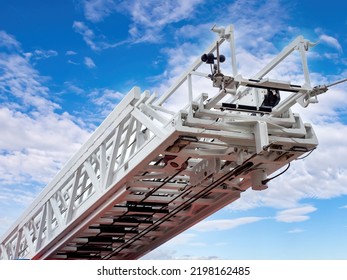 Retractable fire truck ladder. Special equipment rescue service. Retractable ladder on background summer sky. Fragment car rescue service. Concept sale of rescue equipment. White retractable ladder