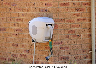 Retractable Garden Hose Reel On The Side Of A House

