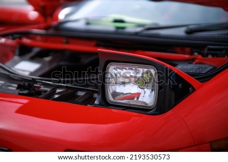 retractable headlight close-up on a red sports car