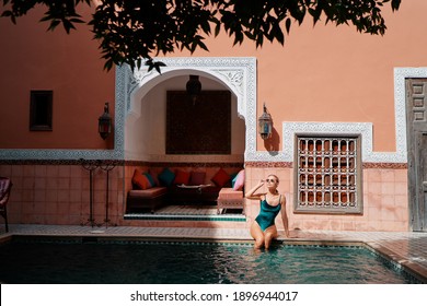 Retreat And Vacation. Beautiful Young Woman Relaxing In Spa Private Swimming Pool In Beautiful Moroccan Backyard.