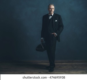 Retro 1920s Doctor In Black Suit With Bow Tie. Holding Handbag.