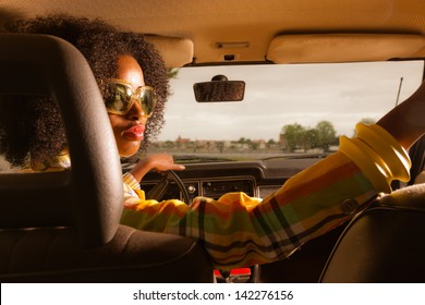 Retro 70s Afro Fashion Woman With Sunglasses Driving In Brown Seventies Car.