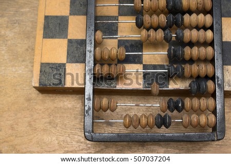 Retro accounting abacus laid on a chess, overhead shot, concept of business and expenses. Overhead cropped shot