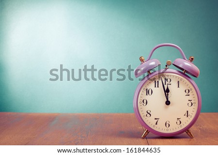 Retro alarm clock with five minutes to twelve o'clock