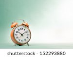 Retro alarm clock on table on mint green background