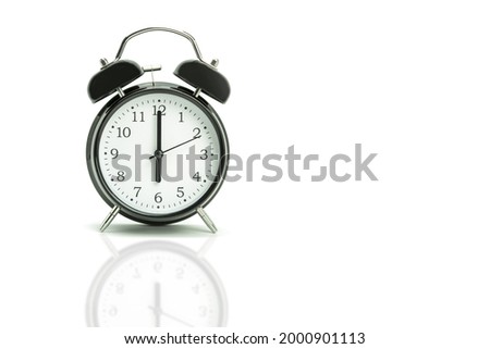 Retro alarm clock on a white background. Black alarm clock showing 6 hours 00 minutes on a white background with copy space