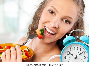 Retro Alarm Clock In Which Woman Make Intermittent Fasting With A Healthy Food Of Salad.