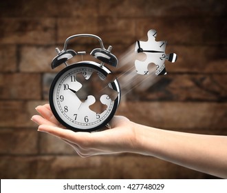 A Retro Alarm-clock On Female Hand On Dark Blurred Background. Lost Time Concept