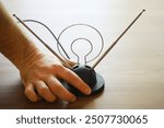 Retro Analog TV Antenna on Wooden Table with Person