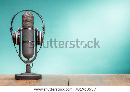 Retro big ribbon microphone and headphones on table front gradient aquamarine background. Vintage old style filtered photo