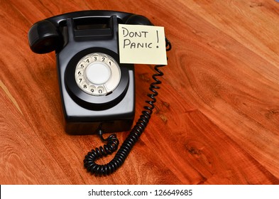 Retro black telephone with reminder note not to panic!