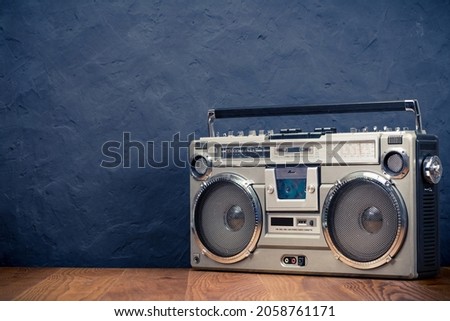 Retro boombox ghetto blaster outdated portable radio receiver with cassette recorder from 80s front concrete black wall background. Rap, Hip Hop music concept. Vintage old style filtered photo