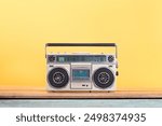 Retro boombox radio cassette recorder from 80s front yellow background. Vintage old style filtered photo