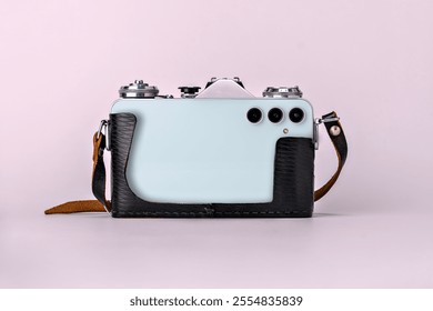 Retro camera with elements of a modern smartphone on a pink background. A creative mix of past and present technologies.