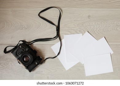 Retro camera and empty old instant paper photo album on wood table with flowers border design - concept of remembrance and nostalgia in spring. vintage style