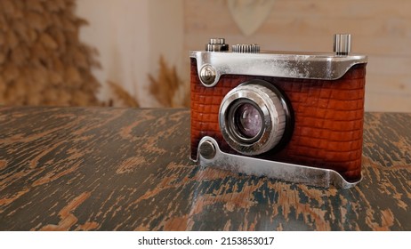 A Retro camera on wooden table in lovely brown design. Designed to revive old 35mm vintage cameras from the 70s and 80s - 3D rendering