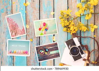 Retro camera and paper photo album on wood table with flowers border design - concept of remembrance and nostalgia holiday in spring. vintage style