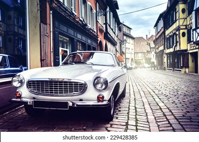 Retro car parked in old European city street - Shutterstock ID 229428385