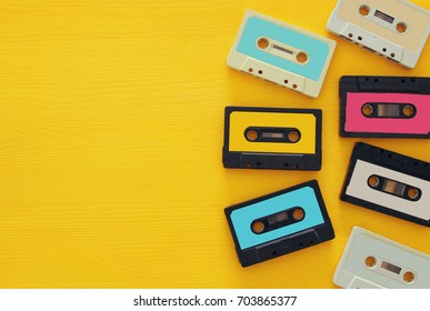 Retro Cassette Tape Collection Over Yellow Wooden Table. Top View. Copy Space.