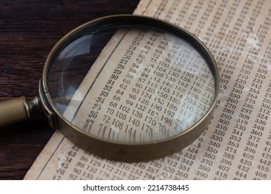 Retro cipher and cryptanalysis. Old vintage magnifying glass with calc table.