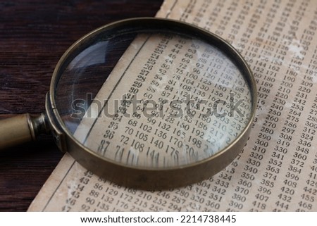 Retro cipher and cryptanalysis. Old vintage magnifying glass with calc table.