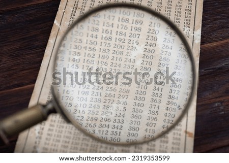 Retro cipher and cryptanalysis. Old vintage magnifying glass with calc table.