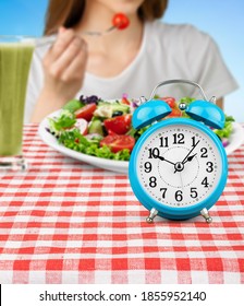 Retro Clock In Which Woman Make Intermittent Fasting With A Healthy Food Of Salad.