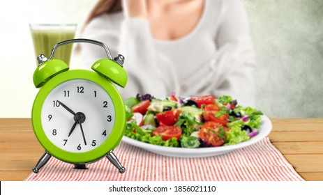 Retro Clock In Which Woman Make Intermittent Fasting With A Healthy Food Of Salad.