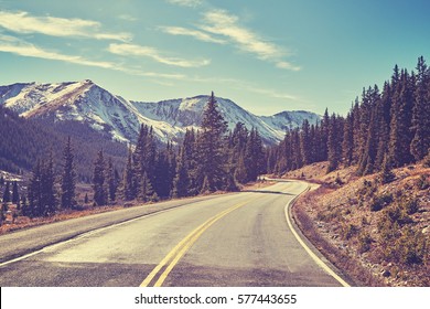 Retro color toned Rocky Mountains road, Colorado, USA.