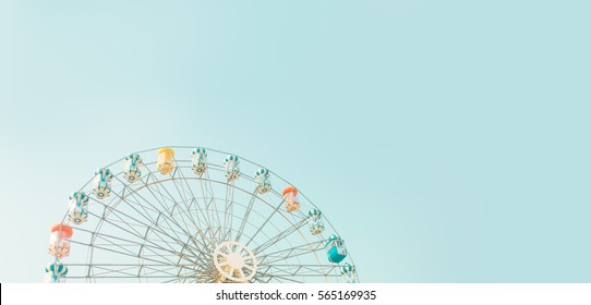 Retro colorful ferris wheel of the amusement park in the blue sky  background.