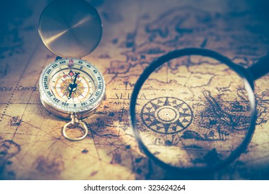 Retro compass on ancient world map, dark vintage style - Shutterstock ID 323624264