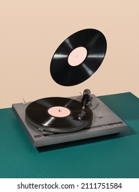 Retro composition of vinyl record player and floating record. Atmosphere of discos, good creative mood and aesthetics of luxurious rest.