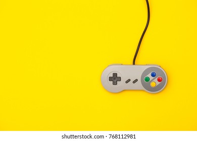 Retro computer gaming controller on a bright yellow background