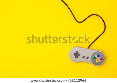 Retro computer gaming controller on a bright yellow background