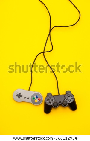 Retro computer gaming controllers on a bright yellow background