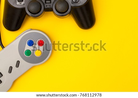 Retro computer gaming controllers on a bright yellow background