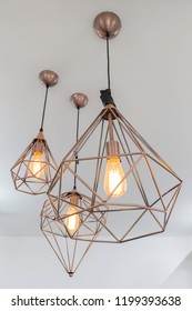 Retro Copper Hanging Lamp With Orange Light Bulb.