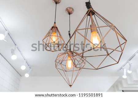 retro copper hanging lamp with orange light bulb.