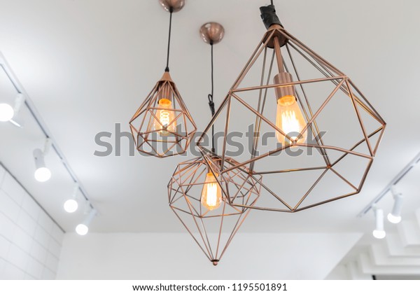 retro copper\
hanging lamp with orange light\
bulb.