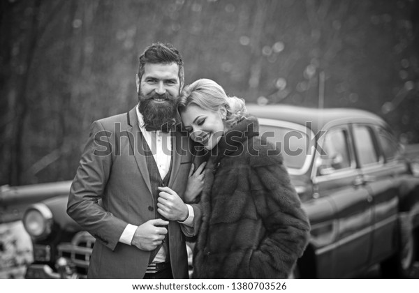 Retro couple\
at vintage car travelling in\
winter.