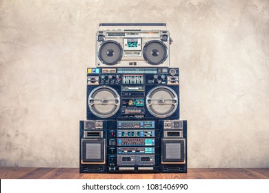 Retro design ghetto blaster stereo radio cassette tape recorders boombox tower from circa 80s front concrete wall background. Vintage instagram old style filtered photo