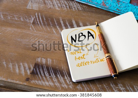 Retro effect and toned image of notebook next to a fountain pen. Business acronym NBA as NEXT BEST ALTERNATIVE with handwritten text