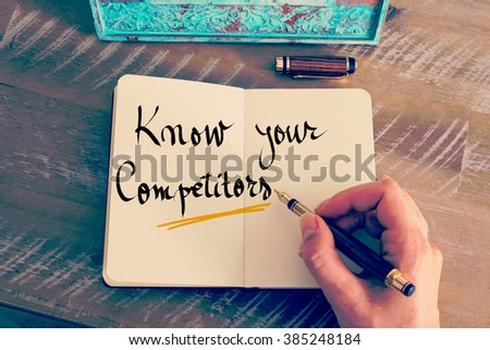 Retro effect and toned image of a woman hand writing a note with a fountain pen on a notebook. Handwritten text Know Your Competitors as business concept image