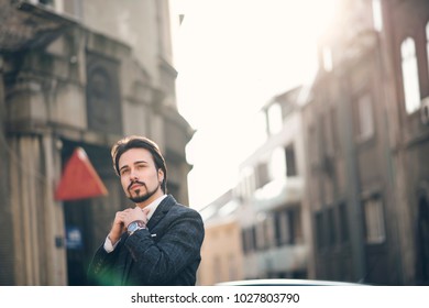 Retro fashioned business man in a typical english suit, tweed coat and waist coat, bearded guy on a street posing