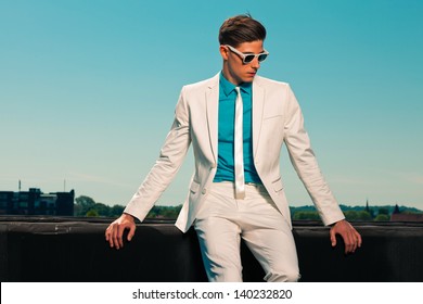 Retro Fifties Summer Fashion Man With White Suit And Sunglasses. On Rooftop. Blue Sky.