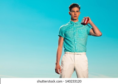 Retro fifties summer fashion man in blue shirt listens to portable radio. Outdoor. Blue sky.
